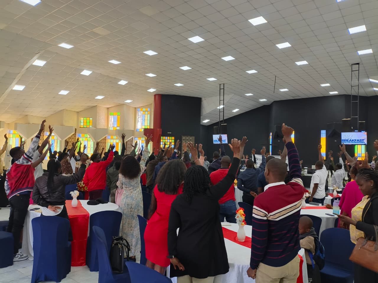 Congregation worshipping with raised hands at a NET gathering
